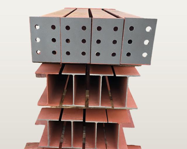 Stack of spliced beam pieces seen end-on: four end plates with six bolt holes each, above plain I-shaped beam ends